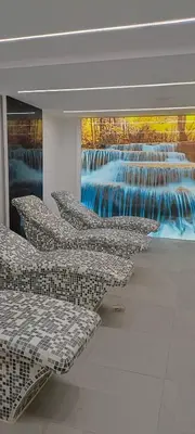 a row of chairs in a building with a waterfall at Apartman Simona President Kop in Kopaonik