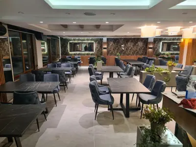 a restaurant with tables and chairs in a room at Apartman Simona President Kop in Kopaonik