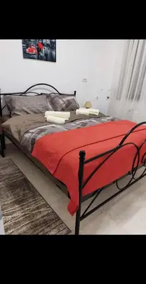 a bedroom with a bed with a red blanket at Apartman Novak Luxury in Aleksandrovac