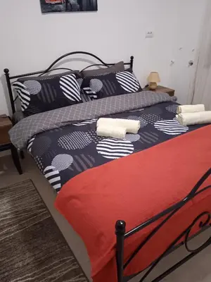 a bed with a black and white comforter and pillows at Apartman Novak Luxury in Aleksandrovac
