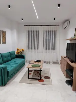 a living room with a green couch and a coffee table at Apartman Novak Luxury in Aleksandrovac