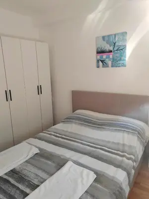 a bedroom with a bed and a painting on the wall at For You Vrnjačka Banja in Vrnjci