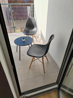 two chairs and a table on a balcony at For You Vrnjačka Banja in Vrnjci