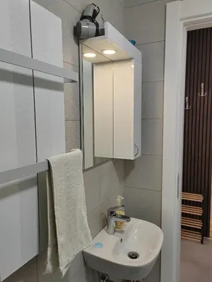 a bathroom with a white sink and a mirror at For You Vrnjačka Banja in Vrnjci