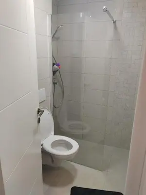 a bathroom with a toilet and a glass shower at For You Vrnjačka Banja in Vrnjci