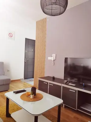 a living room with a coffee table and a tv at For You Vrnjačka Banja in Vrnjci