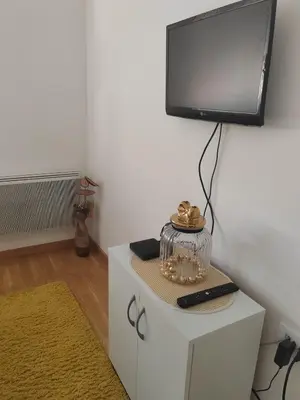 a living room with a tv on top of a white cabinet at For You Vrnjačka Banja in Vrnjci