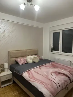 a bedroom with a bed with a pink blanket at Dorin Kutak in Vrnjačka Banja