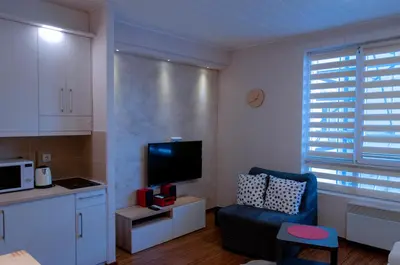 a living room with a blue chair and a tv at Lux Studio Kraljevi Čardaci in Kopaonik