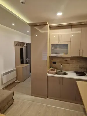 a kitchen with a sink and a living room at Milmari Resort Spa and Wellness, Nlux 52a in Kopaonik