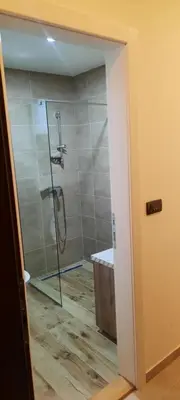 a bathroom with a shower with a glass door at Milmari Resort Spa and Wellness, Nlux 52a in Kopaonik