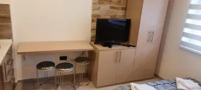 a room with a tv on a cabinet with stools at Milmari Resort Spa and Wellness, Nlux 52a in Kopaonik