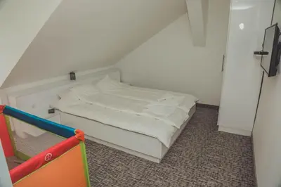 a small white bed in a small room at Luna-L in Vrnjačka Banja