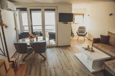 a living room with a table and a couch at Luna-L in Vrnjačka Banja