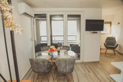 a living room with a glass table and chairs at Luna-L in Vrnjačka Banja