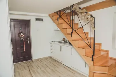 a kitchen with a wooden staircase in a house at Luna-L in Vrnjačka Banja
