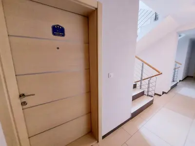 a door with a sign on it next to a staircase at Apartman Maslačak Vrnjačka Banja in Vrnjačka Banja