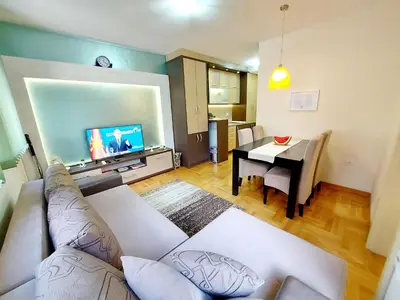 a living room with a couch and a table at Apartman Maslačak Vrnjačka Banja in Vrnjačka Banja