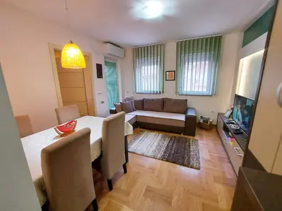 a living room with a table and a couch at Apartman Maslačak Vrnjačka Banja in Vrnjačka Banja