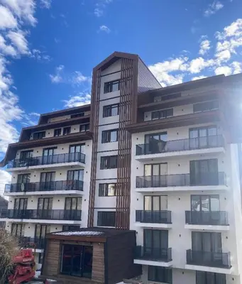 a tall white building with a sky in the background at Zeleni vrh A03 in Kopaonik