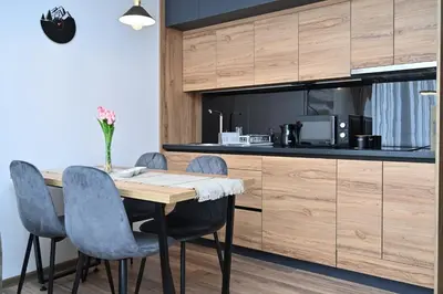 a kitchen with a wooden table and chairs at Zeleni vrh A03 in Kopaonik