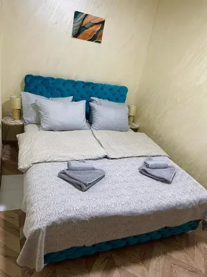 a bedroom with a bed with two towels on it at Pink Apartmani in Jagodina