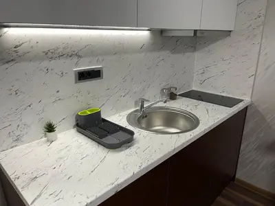 a kitchen counter with a sink and a scale at Pink Apartmani in Jagodina