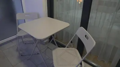 a white table and two chairs next to a window at Astera 1 in Vrnjci