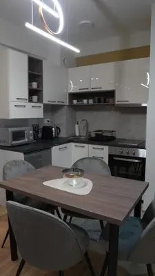 a kitchen with a wooden table and chairs at Astera 2 in Vrnjci