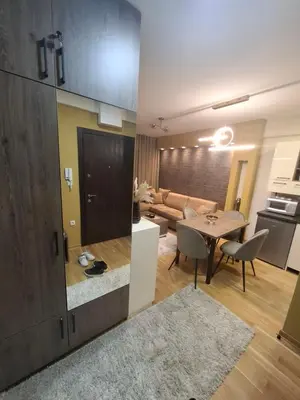 a kitchen and a living room with a table and a couch at Astera 2 in Vrnjci