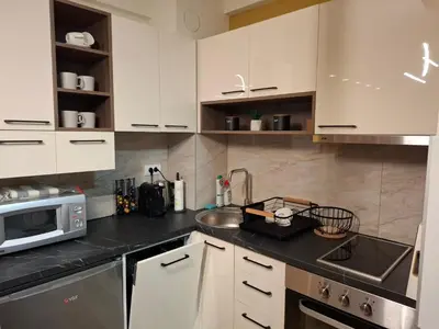 a kitchen with white cabinets and a sink and a microwave at Astera 2 in Vrnjci