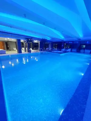 a swimming pool in a building with blue lights at Apartman Mećavnik Kopaonik in Kopaonik