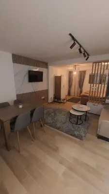 a living room with a table and a couch at Apartman Mećavnik Kopaonik in Kopaonik