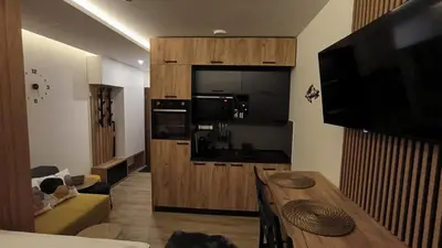 a kitchen with a table and a television in a room at Kopaonik, Apartman FORELIA, Residence hill in Kopaonik