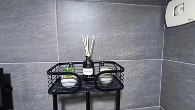 a black shelf with a bottle and sticks in a bathroom at Kopaonik, Apartman FORELIA, Residence hill in Kopaonik