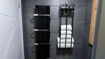 a bathroom with black and white towels in a shower at Kopaonik, Apartman FORELIA, Residence hill in Kopaonik