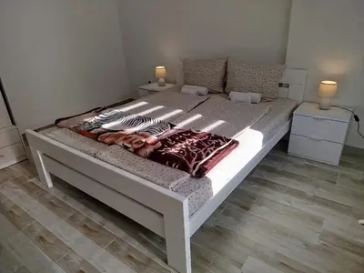 a large white bed in a room with two lamps at Cera residence apartment in Soko Banja