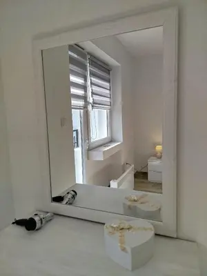a mirror in a white room with a dog laying on the floor at Cera residence apartment in Soko Banja