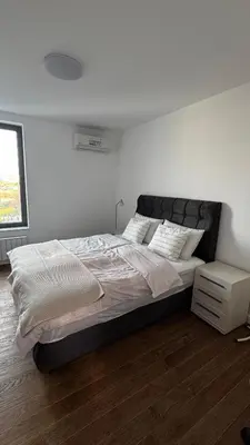 a bedroom with a large bed in a white room at Planet A in Niš
