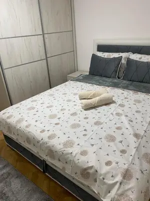 a large bed in a bedroom with a white mattress at Apartmani Ivanović in Vrnjačka Banja