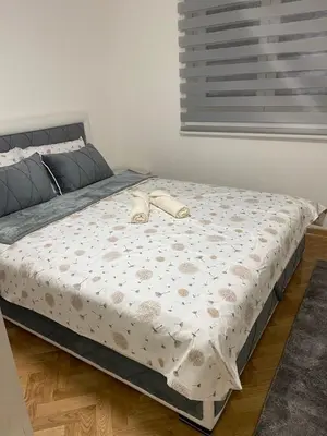 a bed with a pair of shoes sitting on it at Apartmani Ivanović in Vrnjačka Banja