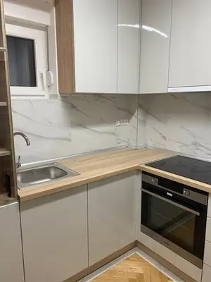 a kitchen with white cabinets and a sink at Apartmani Ivanović in Vrnjačka Banja