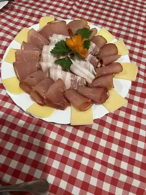 a plate of meat on a red and white table cloth at Ribnjak Filopivic in Pleš