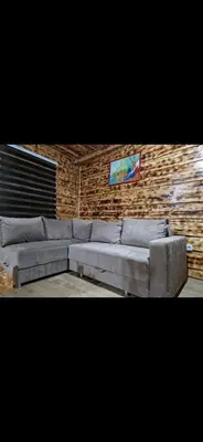 a gray couch in a room with a brick wall at Ribnjak Filopivic in Pleš