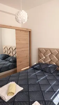 a bedroom with a large bed with a wooden headboard at KopStar Apartment Kopaonik 19 in Kopaonik