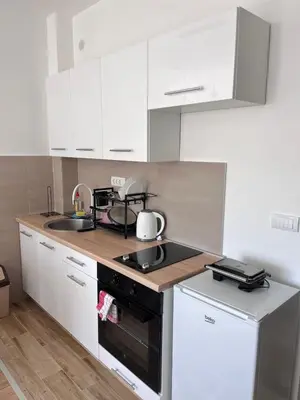 a kitchen with white cabinets and a stove top oven at KopStar Apartment Kopaonik 19 in Kopaonik