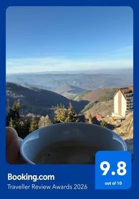 a hand holding a cup with a view of a valley at VAB Apartments & SPA, Residence hill, Kopaonik in Kopaonik