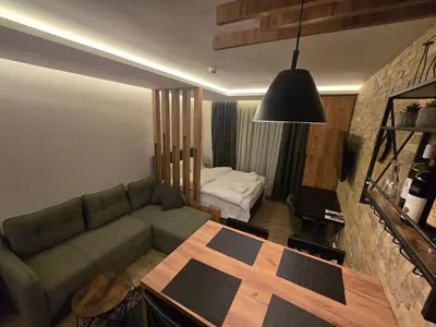 a living room with a couch and a bedroom at VAB Apartments & SPA, Residence hill, Kopaonik in Kopaonik