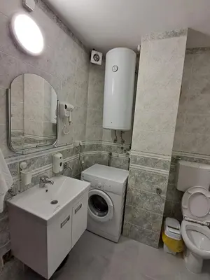 a bathroom with a toilet sink and a washing machine at Zenit apartmani in Niš