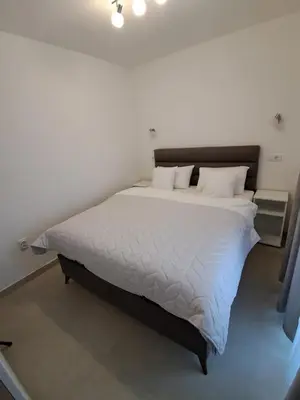 a bedroom with a large bed with white sheets and pillows at Zenit apartmani in Niš